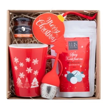 Julete set cadeau thé - Set cadeau thé dans une boîte cadeau en carton kraft avec remplissage en laine de bois et ruban rouge. Comprend : mug de Noël "Perala" ; thé aux fruits des bois "Luis" (30 g) ; miel des bois "Always Gourmet" (50 g) ; infuseur à thé "Strobus" ; décoration de sapin de Noël "Skaland". - Hongrie - noel - cadeaux fin de d'année